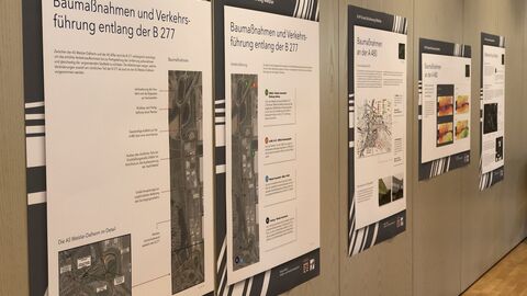 Plakate mit Informationen und Bildern, aufgehängt an einer Wand bei der Öffentlichen Infomesse am 25. Mai 2022