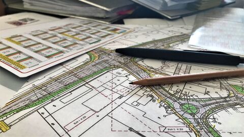 Das Bild zeigt einen Tisch mit Karten und Büromaterial