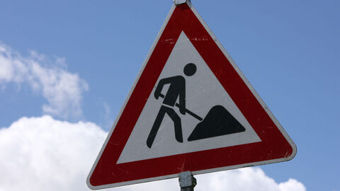 Baustellenschild vor blauem Himmel